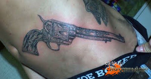татуировка револьвер на боку