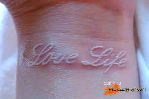белая татуировка на запястье с надписью Люблю Жизнь