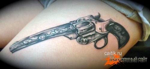 татуировка револьвер на бедре