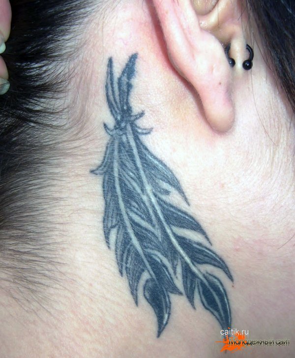 татуировка два пера за ухом