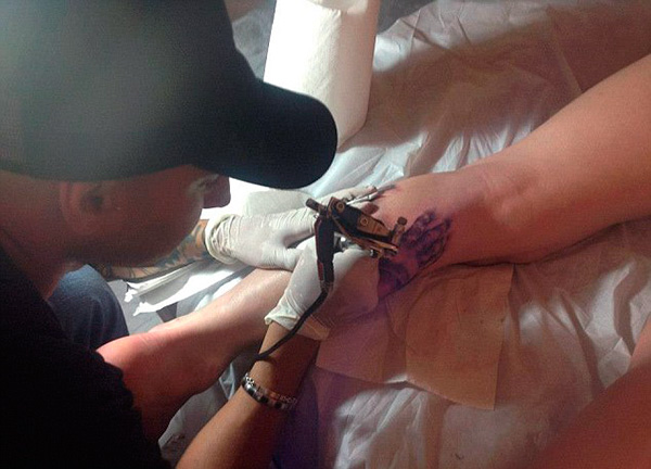 процесс набивания татуировки на ноге